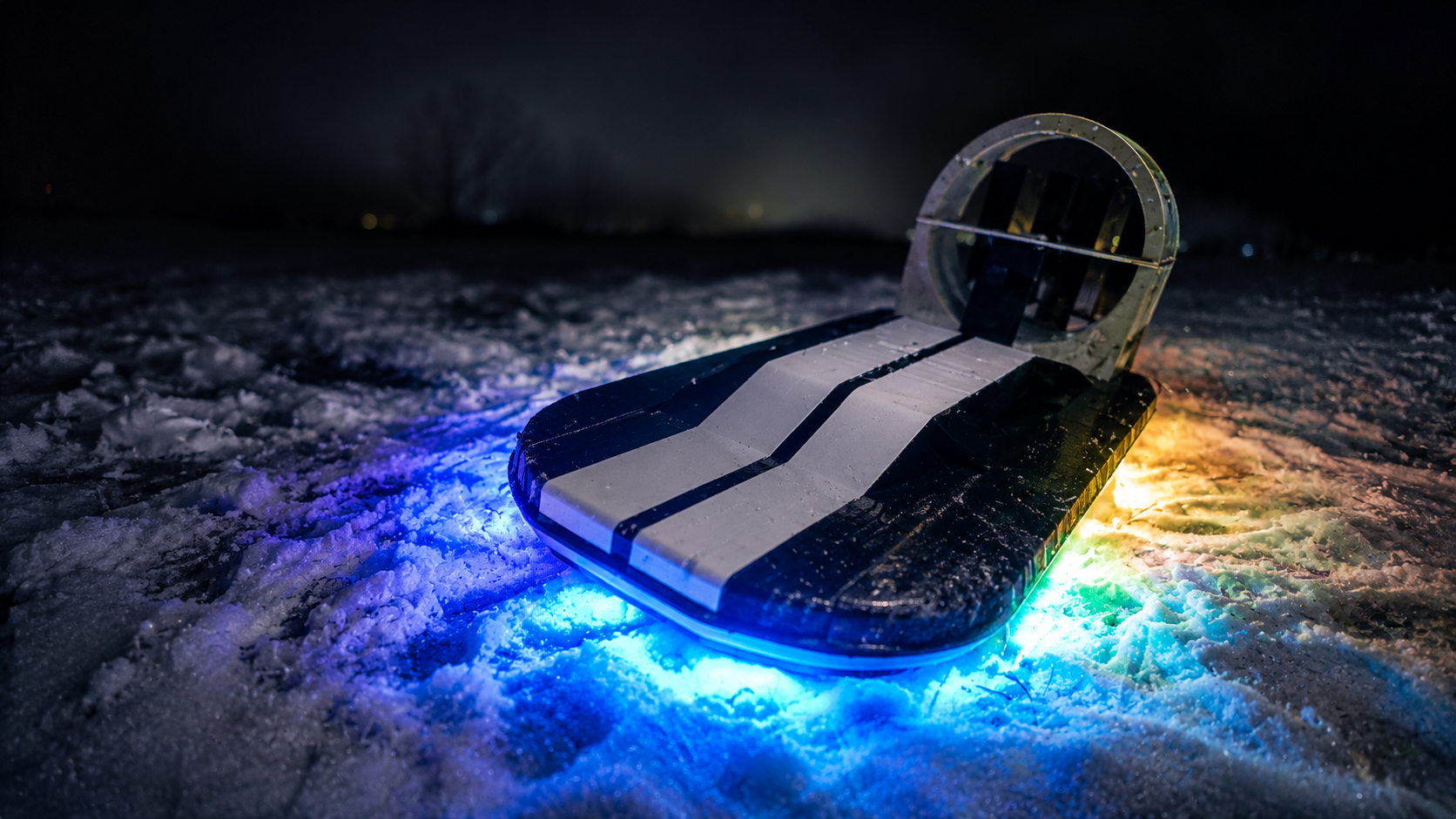 RC hovercraft with RGB underglow lighting up the snow at night
