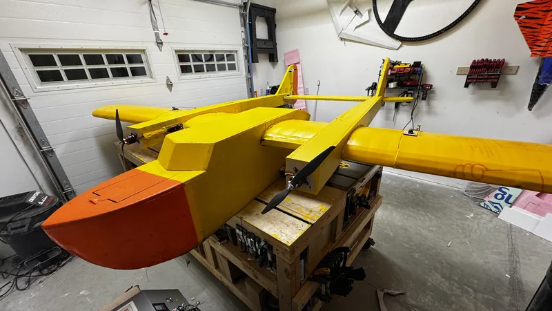 The yellow and orange 20-foot RC airplane on the bench in the garage