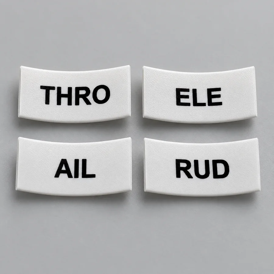 Close-up of four labels, THRO, ELE, AIL and RUD, showing the sharpness of the black print on white